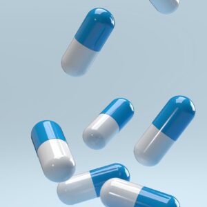 Falling,pills,on,a,blue,background.,antibiotics.,3d,render.