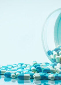 Blue,and,white,capsules,pill,spilled,out,from,white,plastic
