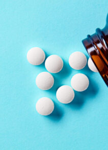 White,medical,pills,and,tablets,spilling,out,of,a,drug