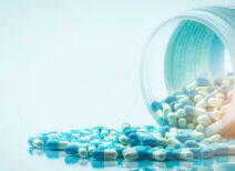 Blue,and,white,capsules,pill,spilled,out,from,white,plastic
